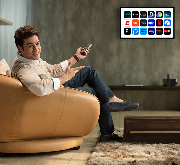 Relaxed viewer browsing the NordikTV IPTV catalogue on a wall-mounted smart TV